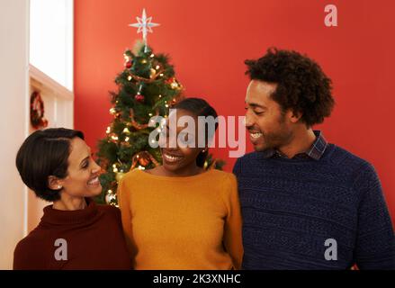 È tempo di aprire i regali: Un gruppo di giovani che festeggiano insieme il Natale. Foto Stock