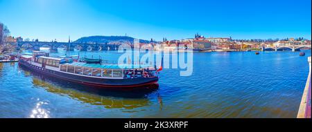 Panorama del fiume Moldava grande nave turistica ormeggiata nel molo e nel quartiere di Mala Strana sullo sfondo, Praga, Repubblica Ceca Foto Stock