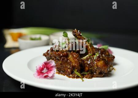 Pollo Szechuan, una ricetta indo-cinese popolare non vegetariana. Servito in un piatto con salsa al peperoncino. Focus selettivo Foto Stock
