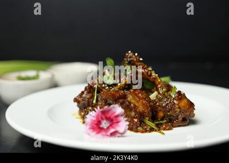 Pollo Szechuan, una ricetta indo-cinese popolare non vegetariana. Servito in un piatto con salsa al peperoncino. Focus selettivo Foto Stock