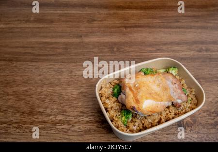 pranzo al sacco a base di pollo e riso fritto sul tavolo in legno Foto Stock