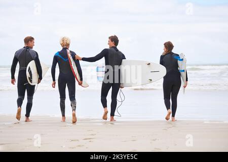 Il surf non è più rinvigorente. I giovani surfisti sono entusiasti di colpire le onde impressionanti. Foto Stock