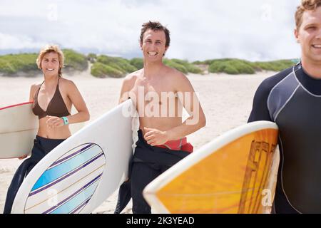 Il surf non è più rinvigorente. I giovani surfisti sono entusiasti di colpire le onde impressionanti. Foto Stock