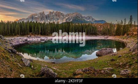 Carezza, Italia - Vista panoramica sul Lago di Carezza con le Dolomiti italiane che si affacciano sul lago. Caldo alba autunnale con colorato Foto Stock