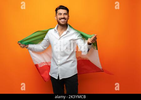 Ritratto di un giovane uomo casual con bandiera dell'Iran su sfondo arancione Foto Stock