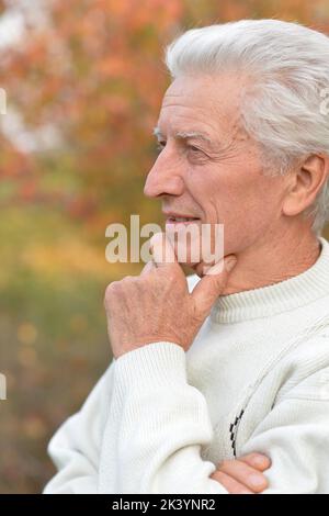 Primo piano ritratto dell'uomo anziano nel parco autunnale Foto Stock