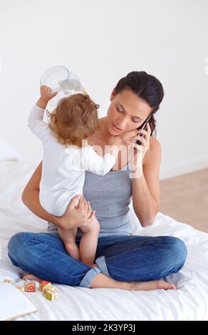 Cercando di equilibrare tutto - maternità. Una bella giovane donna e il suo bambino a casa. Foto Stock