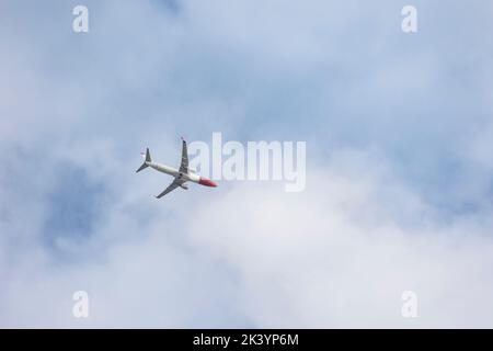 Aereo commerciale che vola contro il cielo azzurro. Foto Stock