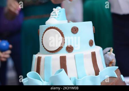 Torta coperta di marzapane blu. Torta con stivali blu in cima Foto Stock