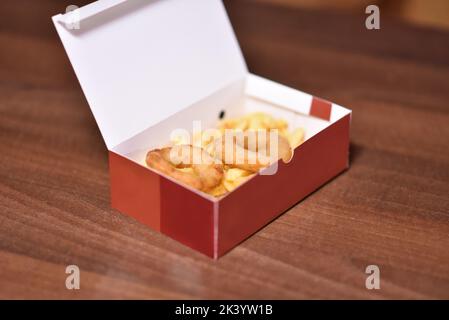 Scatola di cartone con anelli di cipolla fritta croccante su tavola di  legno, primo piano Foto stock - Alamy
