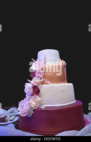 Torta nuziale decorata con perle bianche e fiori e pigmenti d'oro e granato Foto Stock
