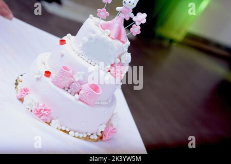 Bella torta di compleanno rosa con piccola statuina in cima Foto Stock