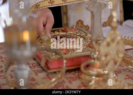 Sacerdote ortodosso che tiene le corone davanti allo sposo e alla sposa Foto Stock