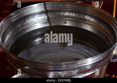 Battesimo ortodosso. Una ciotola di chiesa con acqua. Fonte battesimale. Foto Stock