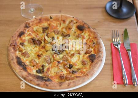 Pizza hawaiana con ananas su sfondo rustico in legno. Foto Stock