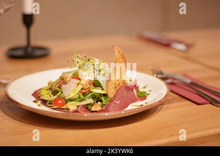 Prosciutto spagnolo con insalata verde, pomodoro e grani di grano. Foto Stock