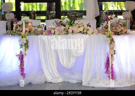 Tavolo per cerimonie nuziali con fiori e tovaglia Foto Stock