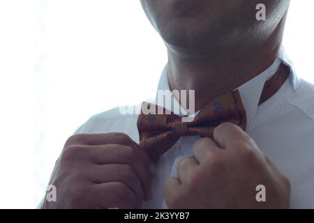 Giovane uomo che gli mette la cravatta intorno al collo. Foto Stock