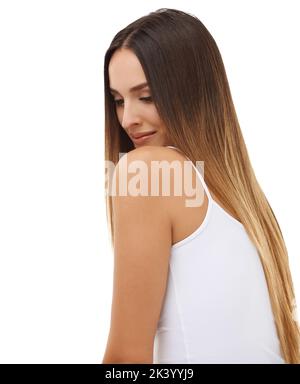 Dolce e timido. Studio shot di una bella giovane donna con capelli lunghi che sfavillano sulla spalla. Foto Stock