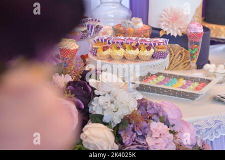 Fiori e dolci vari su un tavolo. Candy bar Foto Stock