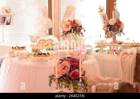 Piatti con vari dolci posti sul tavolo da battesimo Foto Stock