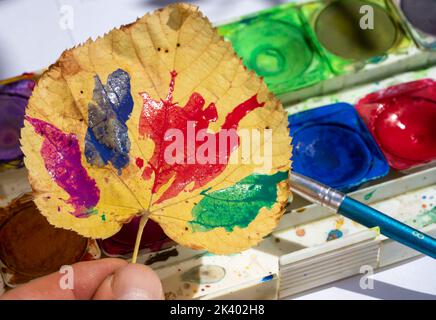 Dipingere le foglie con acquerelli in autunno Foto Stock