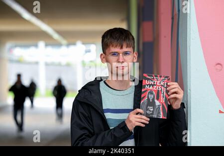 PRODUZIONE - 27 settembre 2022, Sassonia-Anhalt, Halle (Saale): Lo studente e autore Jakob Springfeld si trova a Halle/Saale con il suo libro 'Unter Nazis'. Lo studente Jakob Springfeld di Zwickau è stato onorato per il suo impegno sociale e il coraggio civile come scolaro, tra le altre cose con la Medaglia Theodor Heuss. Nel suo libro 'Unter Nazis' (tra nazisti), descrive gli scontri con la scena di destra nella sua città natale, che un tempo era anche la casa del 'Nazional Socialist Underground'. Foto: Hendrik Schmidt/dpa Foto Stock