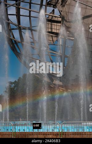 Un arcobaleno visibile visto nelle fontane che circondano l'Unisfera nel Flushing Meadows Corona Park nel Queens, New York City. Foto Stock