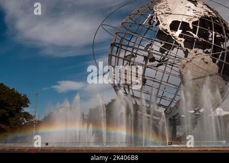 Un arcobaleno visibile visto nelle fontane che circondano l'Unisfera nel Flushing Meadows Corona Park nel Queens, New York City. Foto Stock