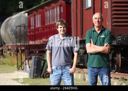 James Waters (con Dad Robin) accanto alla carrozza ferroviaria 1880s che hanno un premio per come una proprietà di affitto di vacanza stravagante, Halstead, Essex UK Foto Stock