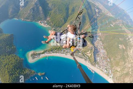 Parapendio a Fethiye, parapendio di Turchia che sorvola la spiaggia di Oludeniz a Fethiye Turchia durante il tramonto. Foto Stock