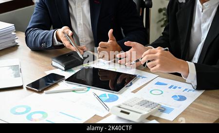 Due imprenditori asiatici professionisti e intelligenti o analisti finanziari maschili che lavorano e discutono i loro dati finanziari sul rapporto insieme nel corso della incontro Foto Stock