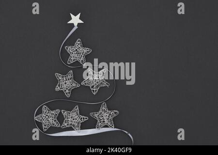 Wireframe Sparkly Silver Stars organizzato come un albero di Natale con una sciarpa d'argento Foto Stock
