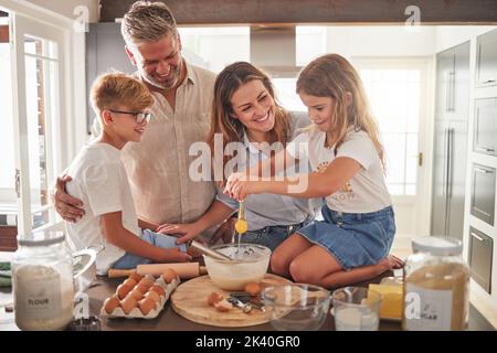 Buona cucina o cottura in cucina con madre, padre o genitori e bambini che imparano per amore, cura e sostegno. Papà, mamma e bambini Foto Stock