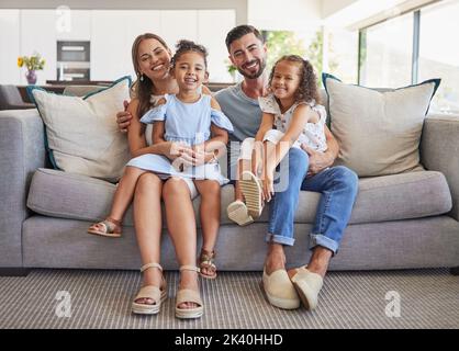 Ritratto di famiglia, felice e sorriso dei genitori con i bambini rilassarsi sul divano del soggiorno in felicità legame. Padre, madre e figli sorridenti nell'amore Foto Stock