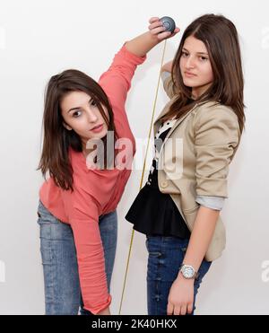 Ragazze con nastro di misurazione isolato in bianco foto stock Foto Stock