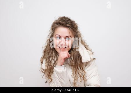 Donna che fa un gesto di hushing alzando il dito sulle labbra come lei chiede il silenzio o per il vostro aiuto nel mantenere una foto segreta di scorta Foto Stock