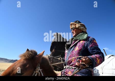 I cacciatori di aquile mongoli, nelle colline rocciose della regione dell'Altai in Mongolia, vivono un gruppo di cacciatori con una competenza estremamente rara: La caccia al golde Foto Stock