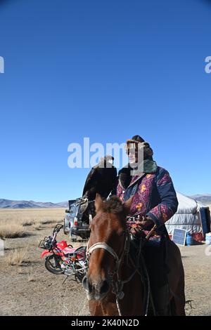 I cacciatori di aquile mongoli, nelle colline rocciose della regione dell'Altai in Mongolia, vivono un gruppo di cacciatori con una competenza estremamente rara: La caccia al golde Foto Stock