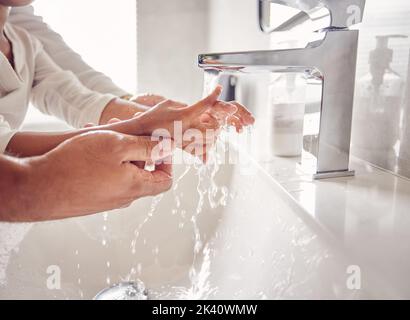 Pulizia, mani e acqua con una ragazza e un uomo nel bagno della loro casa insieme. Bambini, bambini e igiene con il lavaggio di un padre e di una figlia Foto Stock