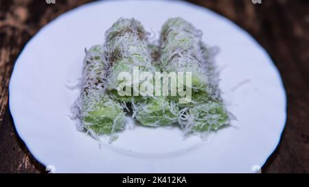 'Kuih putu bambu' è una torta fatta con farina di riso e formata con stampi di bambù. L'aroma delle foglie di panda di questa torta è molto appetitoso. Foto Stock