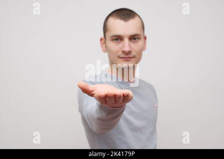 Uomo d'affari che mostra qualcosa sul palmo della sua mano stock foto Foto Stock