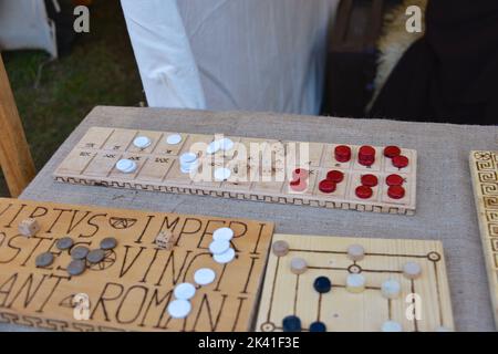 Un dado a osso romano e un banco da gioco su un tavolo di legno Foto Stock