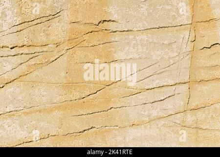 Parete beige con sporco giallo graffiato Foto Stock