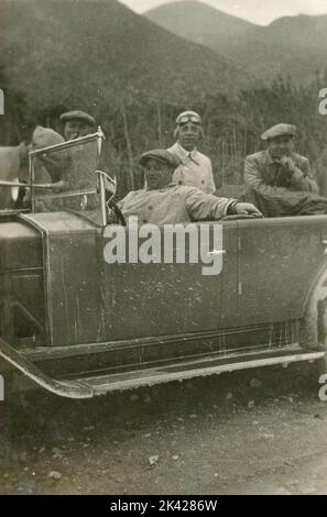 Cinque amici lungo la strada durante un viaggio in auto, Italia 1920s Foto Stock