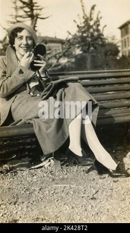 Donna seduta su una panchina, Italia 1930s Foto Stock