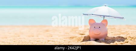 Piggy Bank sulla spiaggia con ombrello. 401k ritirare denaro Foto Stock