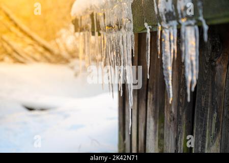 Ghiaccioli sospesi dal tetto Foto Stock