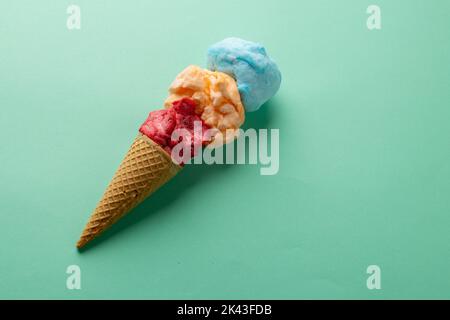 Immagine orizzontale di tre gusti colorati di gelato in cono, su sfondo blu con spazio copia Foto Stock