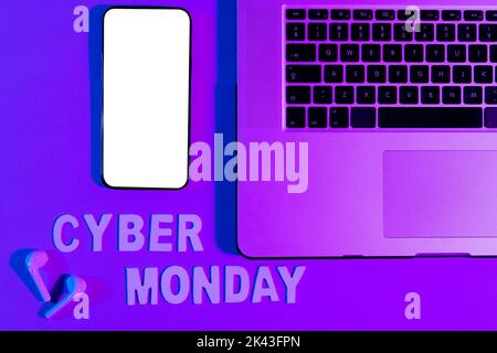 Immagine del testo cyber lunedì, smartphone con spazio copia, computer portatile e auricolari al neon viola Foto Stock